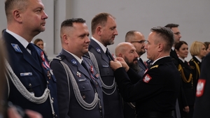 Komendant Główny Państwowej Straży Pożarnej wręcza medal policjantowi