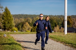 umundurowany policjant i policjantka w trakcie biegu
