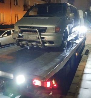 Srebrny samochód marki Mercedes typu van na lawecie w nocy