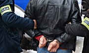 policjanci z zatrzymanym zakutym w kajdanki