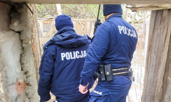 dwaj policjanci w trakcie przeszukiwania pustostanu