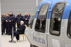 bok śmigłowca, w tle policjanci i inni goście konferencji