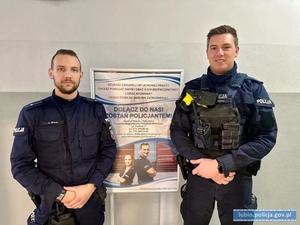 Dwaj policjanci przy plakacie rekrutacyjnym do policji