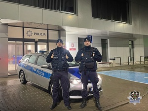 umundurowany patrol policji stojący koło radiowozu
