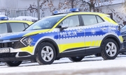 radiowóz policyjny stoi na zaśnieżonej ulicy