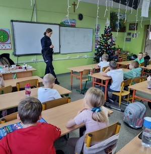 Policjantka w klasie szkolnej rozmawia z dziećmi.