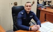 Sierżant Rafał Matyja siedzi za biurkiem