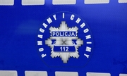 Logo &quot;Pomagamy i chronimy&quot; na drzwiach radiowozu policyjnego.