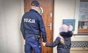 policjant z dziewczynką przy drzwiach domu