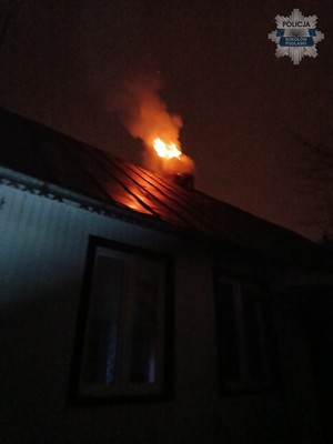 ogień i gęsty dym wydobywający się z komina domu