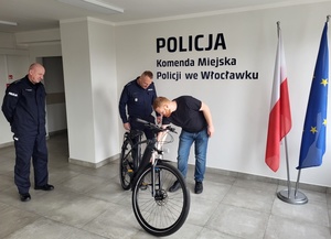 policjanci z obywatelem Niemiec stoją przy rowerze i patrzą na niego
