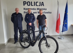 policjanci z obywatelem Niemiec stoją za rowerem