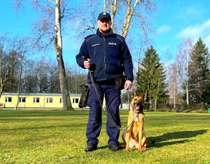 Policjant przewodnik i obok pies służbowy