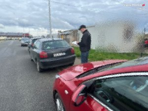 policjant po cywilnemu prowadzi oględziny zaparkowanego auta