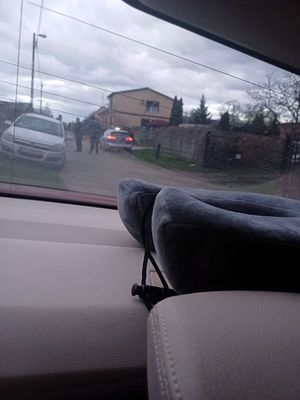 zdjęcie wykonane przez szybę samochodu przedstawia radiowóz policyjny i samochód osobowy zatrzymany przy drodze