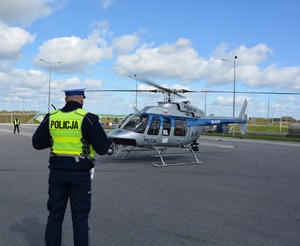 plecy policjanta, w tle śmigłowiec