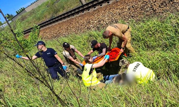 służby stoją w rowie przy torach. Leży tam poszkodowany