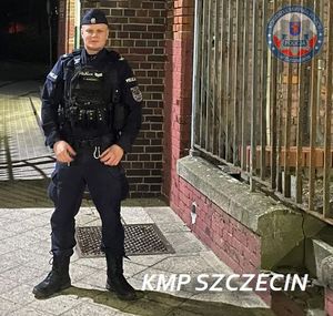 policjant stoi przed budynkiem policji