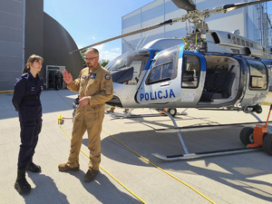 na zdjęciu uczennica klasy policyjnej podczas rozmowy z naczelnikiem Zarząd Lotnictwa Policji Głównego Sztabu Policji KGP insp. pil. Robertem Sitkiem, w tle śmigłowiec Bell 407