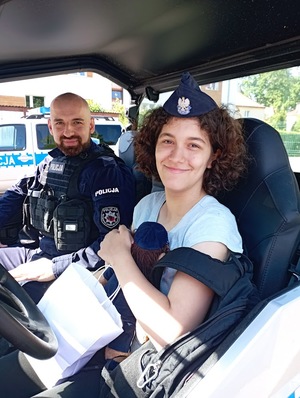 na zdjęciu Ania siedzi z umundurowanym policjantem w radiowozie