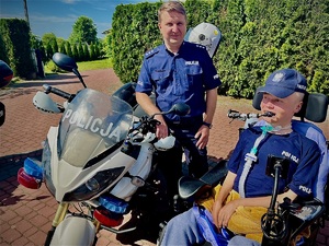 policjant przy motocyklu, obok Wojtek na wózku