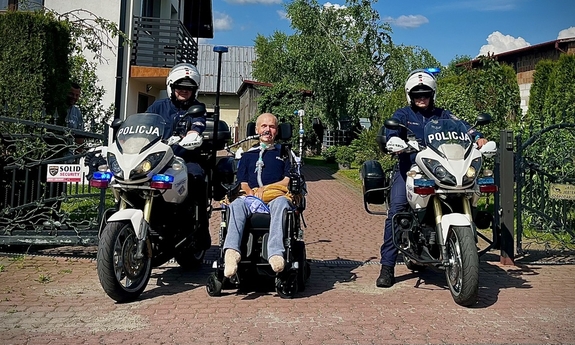 dwaj policjanci na motocyklach, pomiędzy nimi Wojtek na wózku