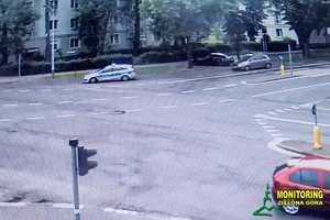 widok eskortującego radiowozu z jadącym za nim pojazdem eskortowanym przejeżdżającego ulicami miasta