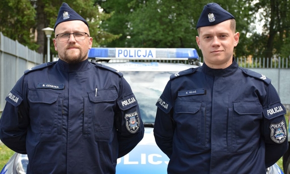 Dwóch policjantów na tle radiowzu
