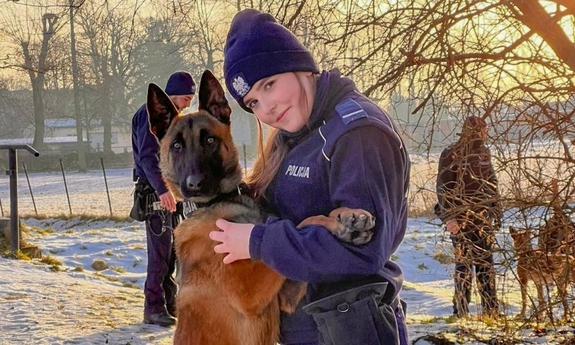 na zdjęciu umundurowana policjantka z policyjnym psem służbowym