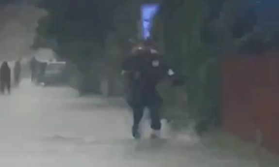 policjant niesie na rękach kobietę