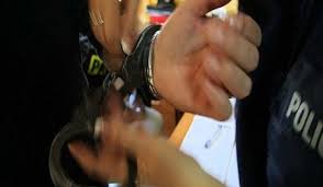 policjant zakłada kajdanki