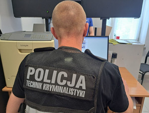 zdjęcie policjanta tyłem w kamizelce z napisem technik kryminalistyki