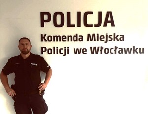 policjant na tle napisu Komenda Miejska Policji we Wrocławiu