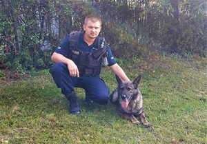 policjant kuca przy swoim psie policyjnym