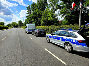 na zdjęciu zatrzymany pojazd stoi wzdłuż drogi i policyjne radiowozy