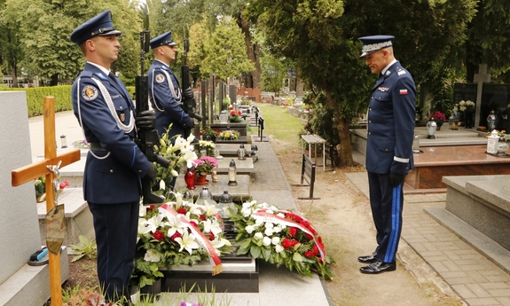 dwaj policjanci na warcie honorowej przy grobie generała Papały, naprzeciwko nich stoi nadinspektor Roman Kuster oddając hołd