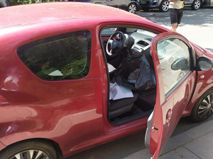 zdjęcie samochodu w kolorze czerwony z otwartymi drzwiami przednimi ukazującymi znajdujące się wewnątrz paczki
