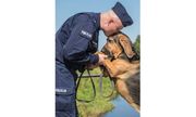 umundurowany policjant całuje służbowego psa