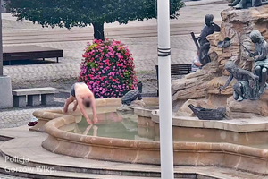 Stopklatka z monitoringu miejskiego przedstawia mężczyznę, który wskakuje do fontanny