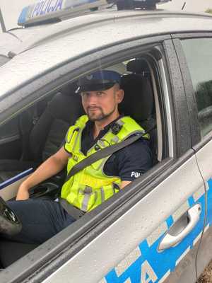 policjant siedzi za kierownicą w radiowozie
