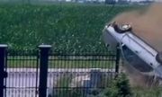 koziołkujący samochód na jezdni przy ogrodzeniu posesji