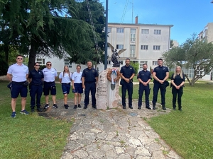 Grupa policjantów przy pomniku na tle budynku