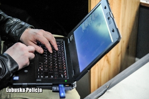 ręce mężczyzny piszą coś na laptopie