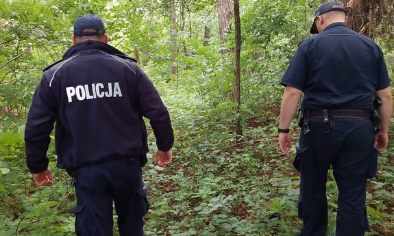 na zdjęciu umundurowani policjanci w trakcie poszukiwań dziadka i 4 letniego wnuczka w lesie