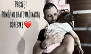 Marcin Wolniewicz z córką na rękach, w tle na białym tle napis: Proszę! Pomóż mi uratować naszą córeczkę