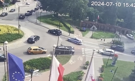 Stopklatka z nagrania monitoringu przedstawia samochody na rondzie, w tym radiowóz eskortujący samochód z kobietą, która urodziła dziecko