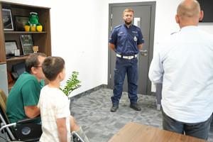 umundurowany policjant w pomieszczeniu służbowym podczas gratulacji