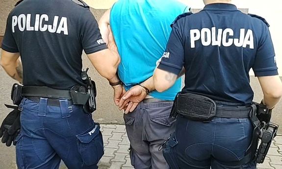dwaj policjanci prowadzą zatrzymanego