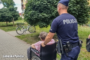 policjant idzie i pcha wózek inwalidzki