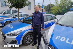 policjant stoi przy radiowozach